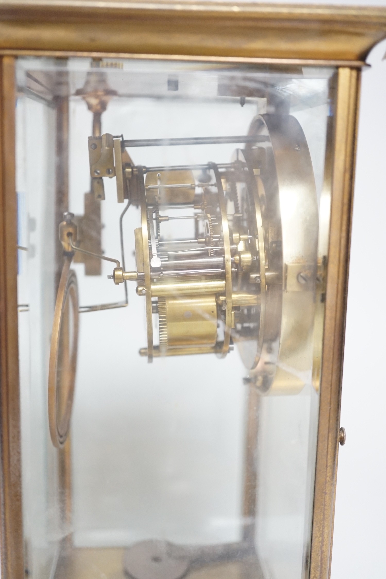 An Edwardian brass four-glass mantel clock with pendulum, presentation plaque to base, 30cm tall